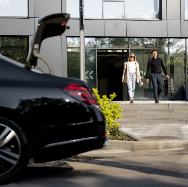Passenger walking to a black Lincoln sedan — Chicago chauffeur service
